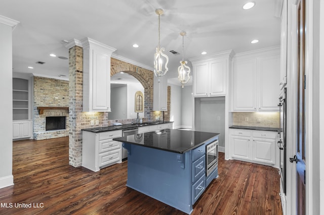 kitchen featuring dark hardwood / wood-style floors, blue cabinets, white cabinets, ornamental molding, and a center island