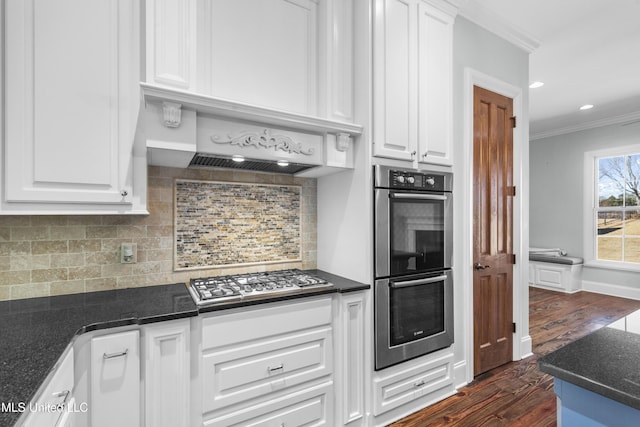 kitchen featuring tasteful backsplash, crown molding, stainless steel appliances, and white cabinets