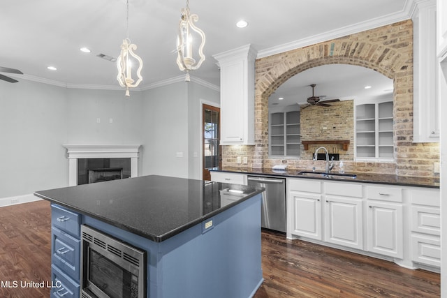 kitchen with appliances with stainless steel finishes, a center island, sink, and white cabinets