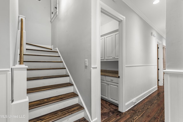 stairway featuring ornamental molding and wood-type flooring