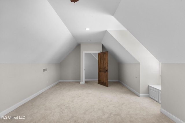 additional living space with lofted ceiling and light carpet