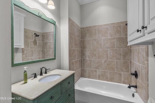 bathroom featuring tiled shower / bath and vanity