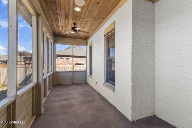 unfurnished sunroom with wooden ceiling and ceiling fan