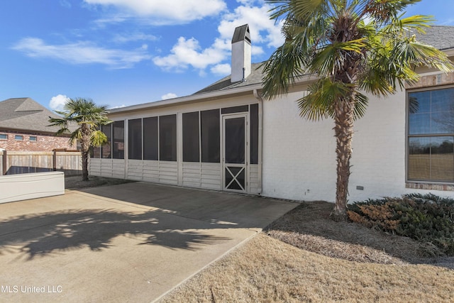 rear view of property with a sunroom and a patio