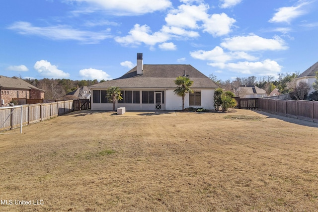 back of property with a sunroom and a yard