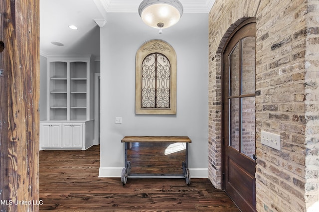 hallway with dark wood-type flooring, ornamental molding, and built in features