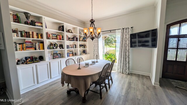 dining room with crown molding, light hardwood / wood-style flooring, and a notable chandelier