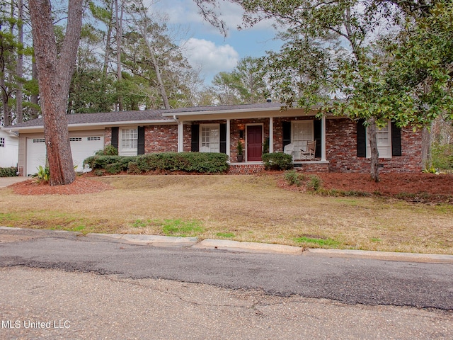 ranch-style house featuring brick siding, an attached garage, and a front yard