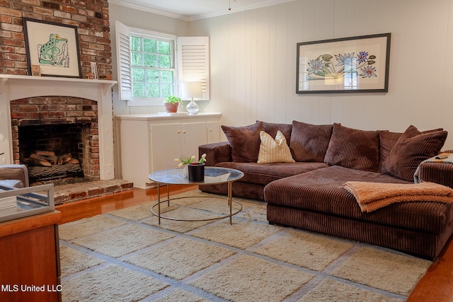 living area featuring a brick fireplace, ornamental molding, and wood finished floors