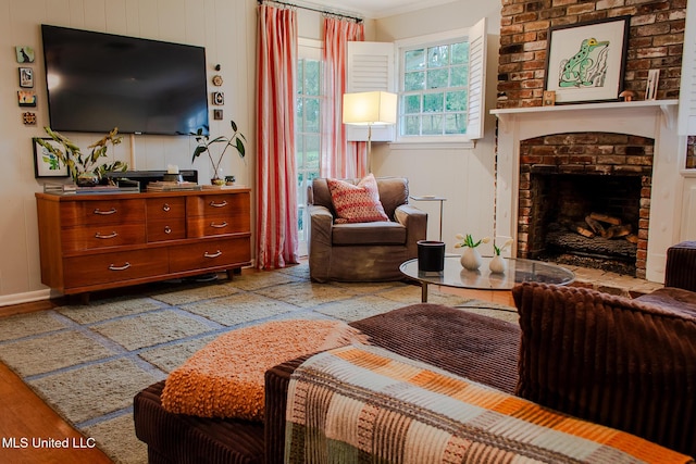 living room with a brick fireplace and wood finished floors