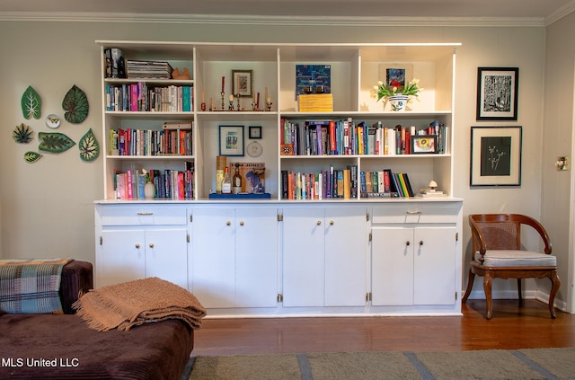 sitting room featuring ornamental molding and wood finished floors