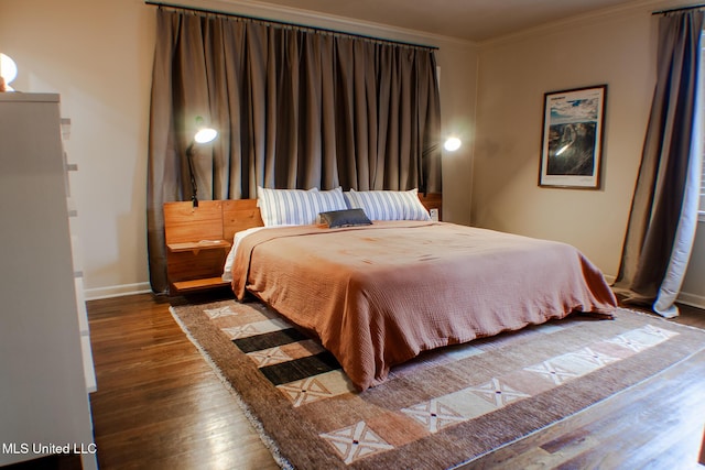 bedroom with crown molding, baseboards, and wood finished floors