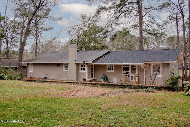 back of property featuring a yard and a chimney