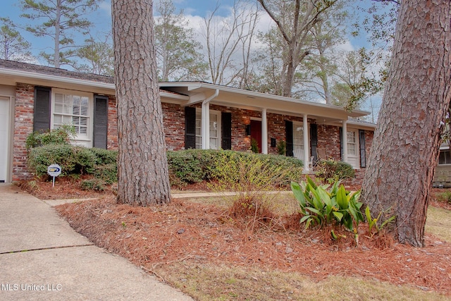 ranch-style home featuring a porch and brick siding