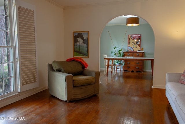 sitting room with hardwood / wood-style flooring, baseboards, ornamental molding, and arched walkways