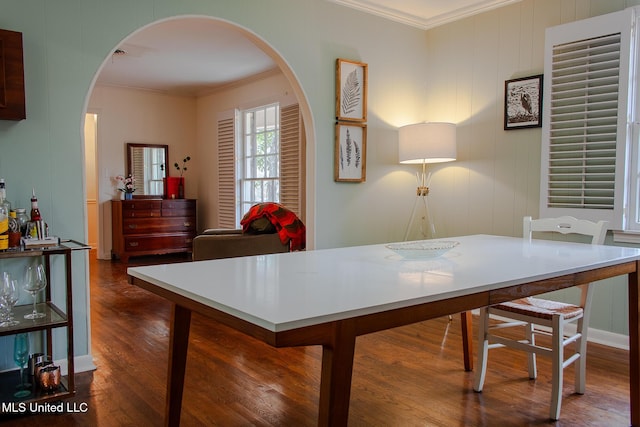 office area with dark wood-type flooring, arched walkways, and crown molding