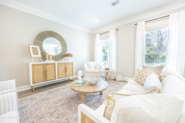 living area featuring hardwood / wood-style floors, crown molding, and a healthy amount of sunlight