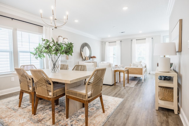 dining space featuring crown molding, a notable chandelier, and light wood-type flooring