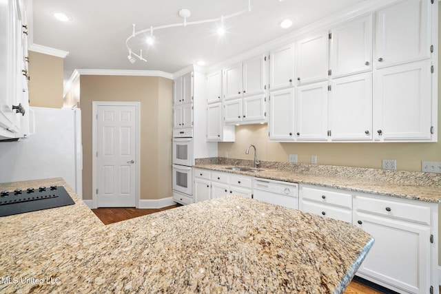 kitchen featuring a sink, white appliances, white cabinets, wood finished floors, and crown molding