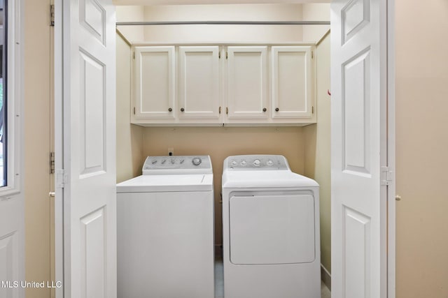 clothes washing area with cabinet space and separate washer and dryer
