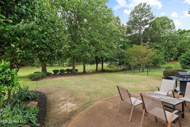 view of yard with a patio area and view of wooded area