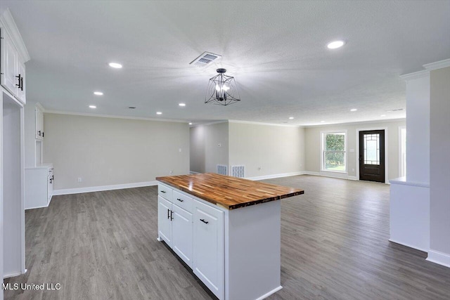 kitchen featuring butcher block counters, white cabinets, light hardwood / wood-style flooring, and a kitchen island