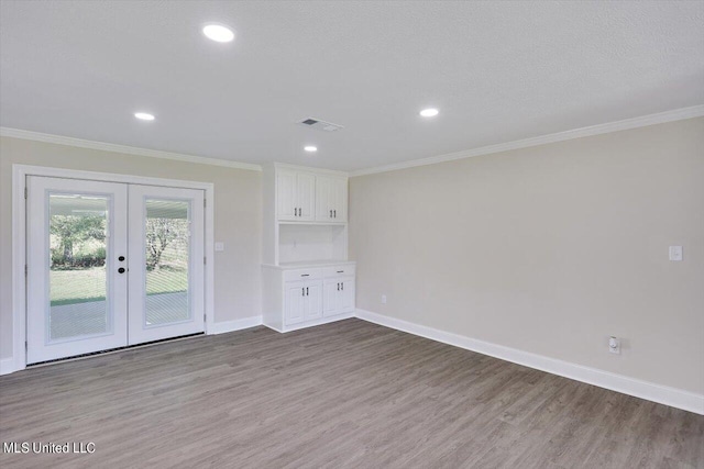 unfurnished living room featuring french doors, ornamental molding, a textured ceiling, and light hardwood / wood-style flooring