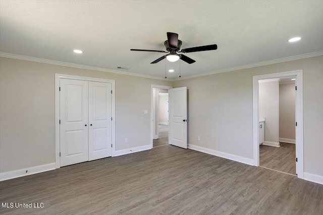 unfurnished bedroom featuring crown molding, ceiling fan, a closet, and wood-type flooring