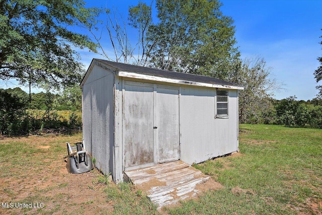 view of outbuilding featuring a lawn