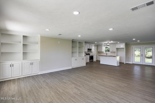 unfurnished living room with sink, dark hardwood / wood-style floors, crown molding, and a textured ceiling