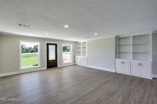 unfurnished room featuring dark wood-type flooring and a textured ceiling