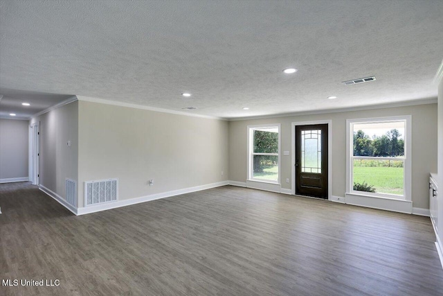 empty room featuring a textured ceiling, dark hardwood / wood-style flooring, plenty of natural light, and crown molding