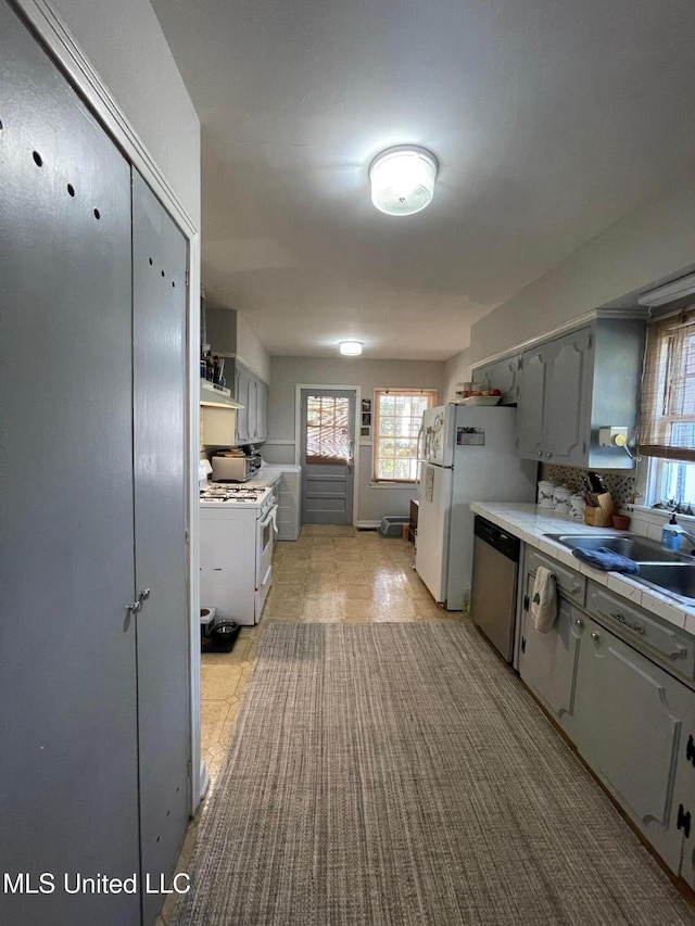 kitchen featuring white appliances, gray cabinetry, and sink