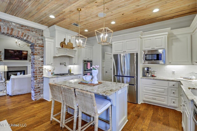 215 Grayhawk Dr, Madison, MS 39110 - kitchen with stainless steel appliances, a chandelier, wooden ceiling, tasteful backsplash, and white cabinets