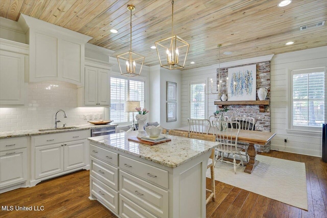 215 Grayhawk Dr, Madison, MS 39110 - kitchen with healthy amount of natural light, wooden ceiling, dark wood finished floors, a kitchen island, and light stone countertops