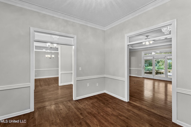 empty room with crown molding, a notable chandelier, a textured ceiling, and dark hardwood / wood-style flooring