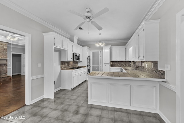 kitchen featuring tile counters, tasteful backsplash, stainless steel appliances, and kitchen peninsula