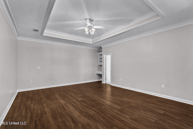 unfurnished room with dark wood-type flooring, ornamental molding, a raised ceiling, a textured ceiling, and ceiling fan