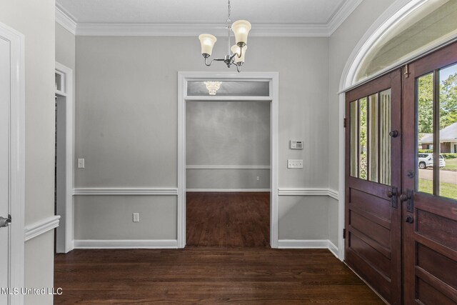 foyer entrance with a notable chandelier, dark hardwood / wood-style floors, and crown molding