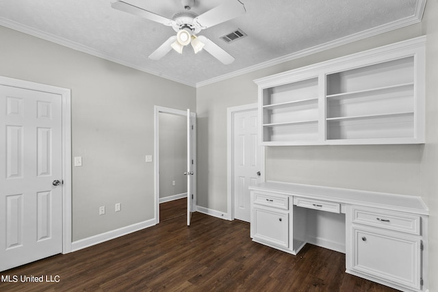 unfurnished office with dark hardwood / wood-style floors, built in desk, ornamental molding, a textured ceiling, and ceiling fan