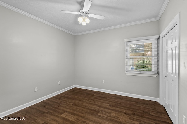 empty room with ornamental molding, dark wood-type flooring, a textured ceiling, and ceiling fan