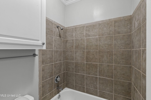 bathroom featuring crown molding, tiled shower / bath combo, and toilet