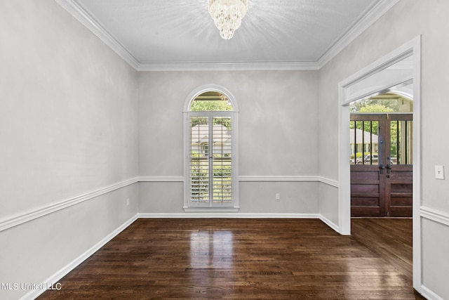 spare room with ornamental molding, dark wood-type flooring, a notable chandelier, and french doors