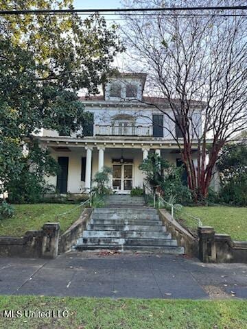 view of front of property featuring covered porch and a front lawn