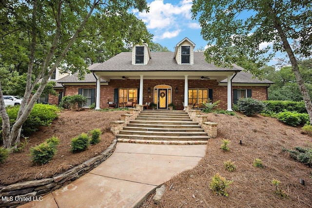 view of front of property with covered porch, brick siding, and stairs