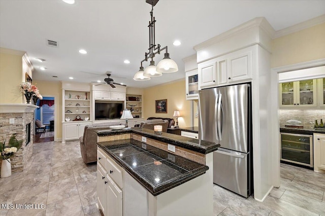 kitchen with stainless steel fridge, white cabinets, a kitchen island, and beverage cooler