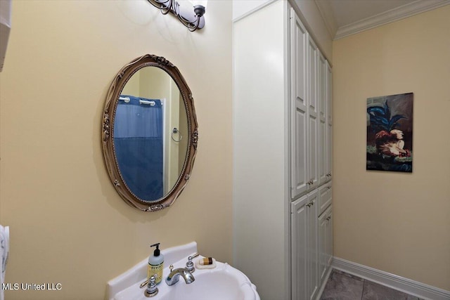 bathroom featuring ornamental molding, sink, and tile patterned flooring