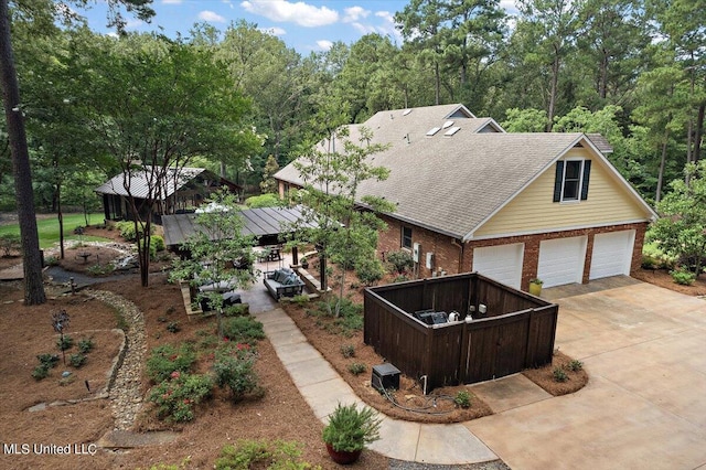 view of front of property with brick siding, driveway, a garage, and roof with shingles