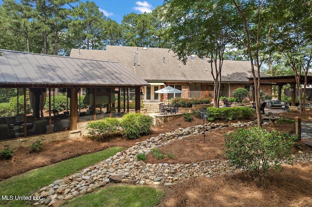 rear view of property featuring a patio area and a sunroom