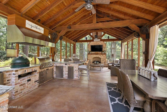 view of patio / terrace with a grill, a gazebo, an outdoor stone fireplace, a ceiling fan, and an outdoor kitchen